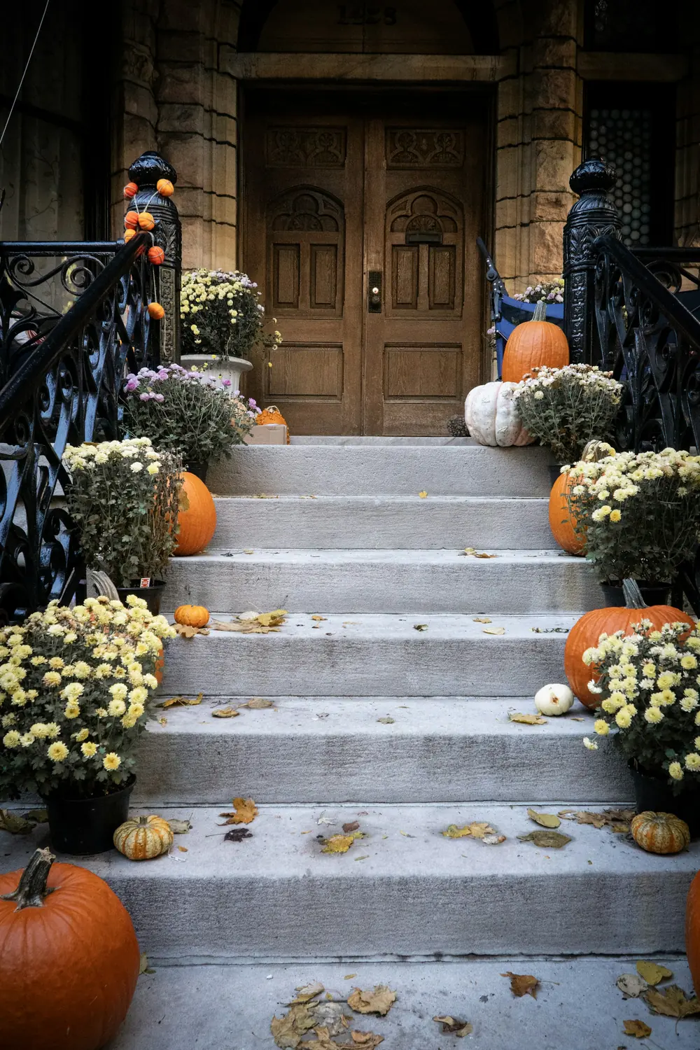 Custom display inspiration: pumpkins and flowering mums arranged along a broad stone entrance stairway